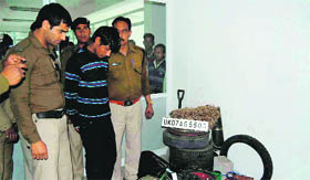 The apprehended youth with the recovered stolen car parts in Mussoorie on Friday.