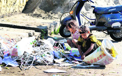 Two girls rummage through garbage in a street on International Womens Day in Haridwar on Friday.