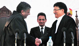 Chief Justice of the Jammu and Kashmir High Court MM Kumar (left) congratulates one of the newly appointed judges in Jammu on Friday.