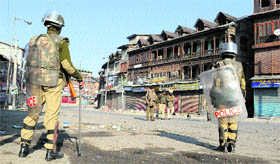Policemen patrol the curfew-bound Srinagar on Friday.