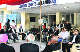 Advocates sit idle as they >> observe a strike on the premises of judicial courts in Jalandhar on Friday.