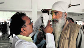 A doctor examines a patient at a free eye check-up camp at Malri village, near Nakodar.