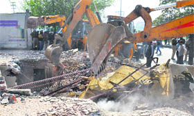 An earthmoving machine razes encroachments on Chandigarh Road in Ludhiana on Friday.
