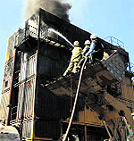 Fire fighters from the Army douse a blaze at a bitumen mixing plant in Udhampur