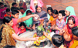 Devotees pour milk on Shivlinga at a temple on Amrik Singh road