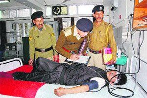 Police personnel record the statement of Dawa Dhundup at a hospital in Dharamsala on Sunday