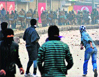 Protesters throw stones towards CRPF men during a protest in Srinagar. 