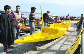  Boatmen paint a boat on the banks of Dal Lake in Srinagar on Sunday.