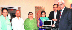 Governor NN Vohra and his wife Usha Vohra presenting a laptop to Mimansha Choudhary at Raj Bhawan in Jammu on Monday. A Tribune photograph