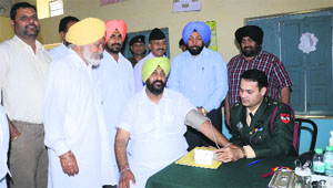 An Army doctor examines patients at the medical camp held in village Balluana.