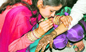 Two girls participate in a mehndi competition at HPU Regional Centre, Dharamsala.