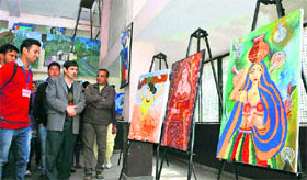 Visitors have a look at the paintings in an exhibition organised by the Visual Arts Department of Himachal Pradesh University in Shimla recently.