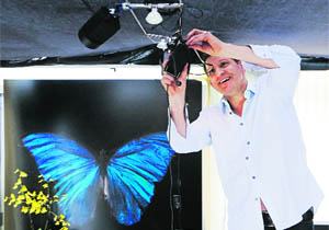 Lensman Alexander James adjusts lighting during a demonstration in London on Monday. James creates still life images underwater often using butterflies as part of the composition.