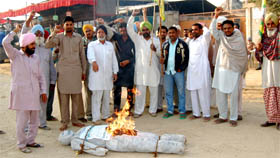 Members of the Bharatiya Kisan Union (Ugrahan) burn an effigy of the state government at village Mehma Serja in Bathinda district on Wednesday.