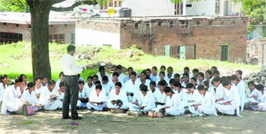 A class in progress under the shade of a tree at a government school in Jammu on Wednesday. Tribune photo: Anand Sharma