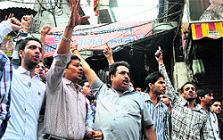 Shopkeepers of the Gur Mandi area raise slogans against the demolition drive of the MC in Ludhiana on Wednesday