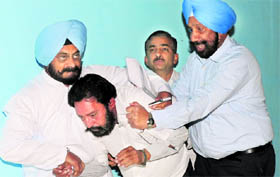 Assistant Sub Inspector Jaipal Singh being roughed up by Congress MLAs in the Vidhan Sabha in Chandigarh on Wednesday.
