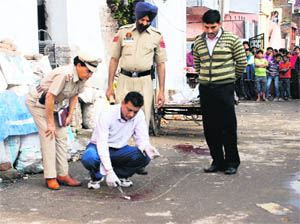 A forensic expert takes samples from the crime scene at Ram Darbar in Chandigarh on Thursday.
