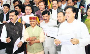 BJP Legislators hold a protest after staging a walkout from the House on the opening day of the Budget session in Dehradun on Thursday.