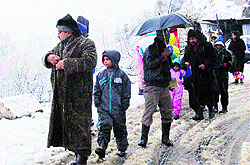 Tourists caught in snowfall near Nehru Kund on the Manali-Rohtang road on Thursday