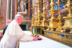 Right beginning: Pope Francis lays a wreath prior to a prayer at Rome's Santa Maria Maggiore basilica on his first day as the head of the Catholics on Thursday.  AFP