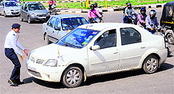 A traffic policeman tries to stop a car at Sector 26 in Chandigarh on Friday