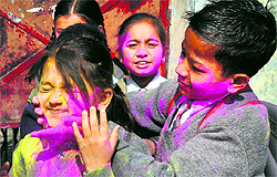 Students smear colour on each other to celebrate Holi as their school closed in Dehradun on Friday