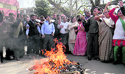 BJP workers burn an effigy of the state government at Clock Tower in Dehradun on Friday