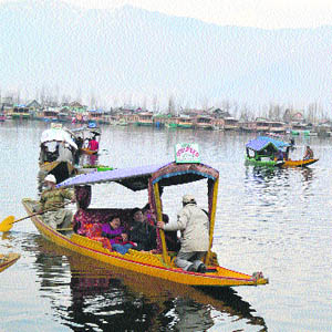 Tourists enjoy a shikara ride during relaxation in curfew on the Dal Lake in Srinagar on Friday. 