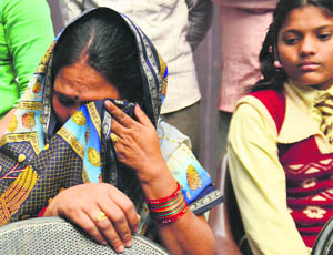 The mother of an injured child, who has been admitted to the CMCH, wipes her tears.
