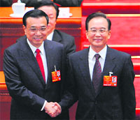 Newly elected Chinese Premier Li Keqiang (L) shakes hands with former Premier Wen Jiabao in Beijing on Friday