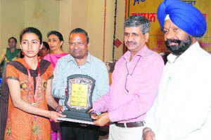 Cheif Parliamentary Secretary Sarup Chand Singla hands over trophy to a student of Government Rajindra College at a function held on Saturday. 