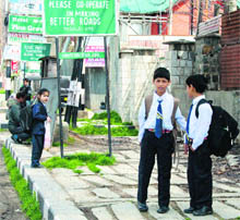 Students wait for a school bus in Srinagar on Saturday. 