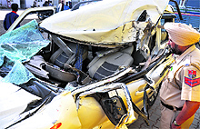 A policeman inspects a damaged SUV near the Jawadi bridge in Ludhiana on Saturday