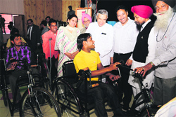 Pawan Bansal, Union Minister for Railways (fourth from right), distributes tricycles among differently abled persons at the Bal Bhawan in Chandigarh on Sunday. Tribune photo: Parvesh Chauhan
