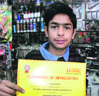 A student shows the certificate issued after the arts competition by an insurance company.