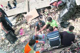 Workers retrieve beer and liquor from the debris at the Sauli khad locality in Mandi on Wednesday