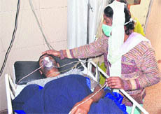 An injured Naresh Malhotra, who was stabbed by robbers, undergoes treatment at a hospital in Jalandhar on Sunday.