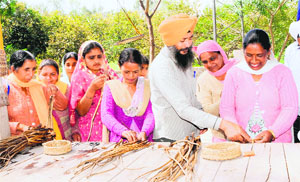 Forest official Atma Singh imparts training to womenfolk from villages adjoining Harike in making handicraft items from water hyacinth. 