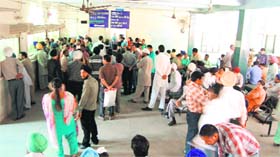 People wait for their turn outside the Revenue Office in Amritsar on Monday
