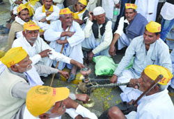 Members of the Jat community enjoy hukka in a group during their demonstration for reservation in government jobs, in New Delhi on Monday. 