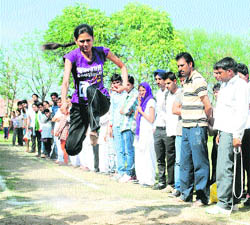 A participant leaps in the air in the athletics meet of the Jan Nayak Chaudhary Devilal Vidyapeeth at Sirsa.