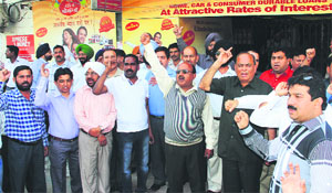 Bank employees hold a protest against the new bank licencing policy at Company Bagh in Jalandhar on Monday.
