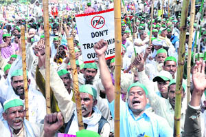 Farmers raise slogans against the procurement of their land for setting up industry at Parliament Street in New Delhi on Monday. 