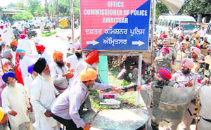 A policeman tries to snatch a mike from a protester in Amritsar