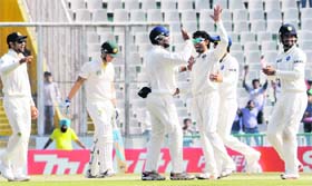 Team India celebrates after the dismissal of Michael Clarke in the third Test in Mohali on Monday