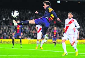 Barcelonas Lionel Messi scores as a Rayo Vallecano player watches on during their Spanish La Liga match on Sunday