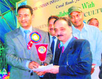 Nawang Rigzin Zora, Minister for Urban Development, gives prize to DN Chauhan, during the kissan mela and flower show, at Jammu.