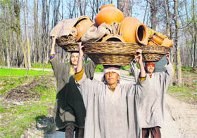Women carry earthen pots in Budgam, west of Srinagar, on Tuesday.