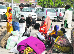 Migrant labourers wait for a train at the Ludhiana railway station
